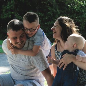Famille rit sur une couverture lors d'un shooting lifestyle à Saint-Hilaire-du-Harcouët en Normandie.
